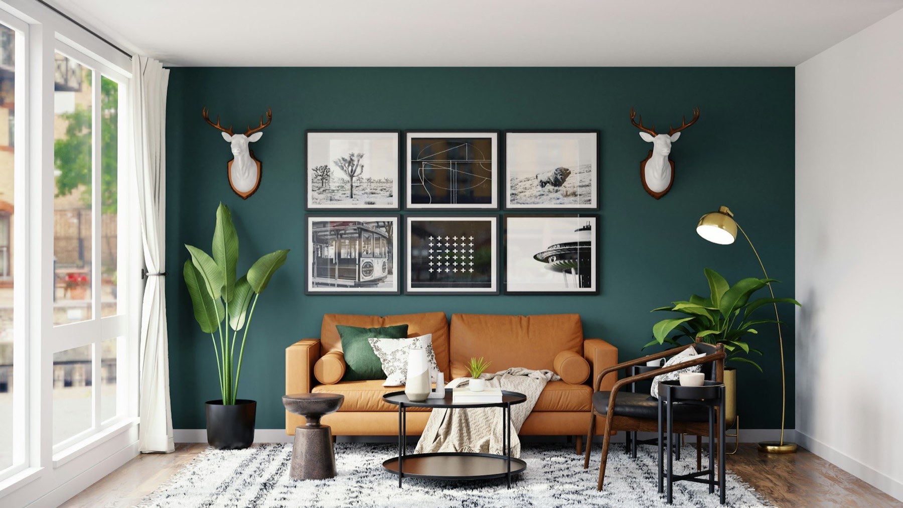 Study in deep green with a framed print wall and tan leather sofa