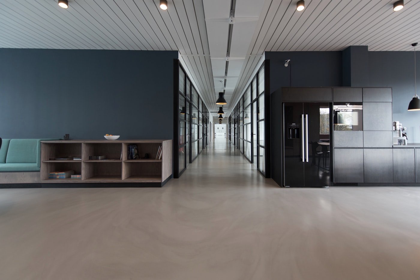 Long service corridor with exposed structure and joinery runs