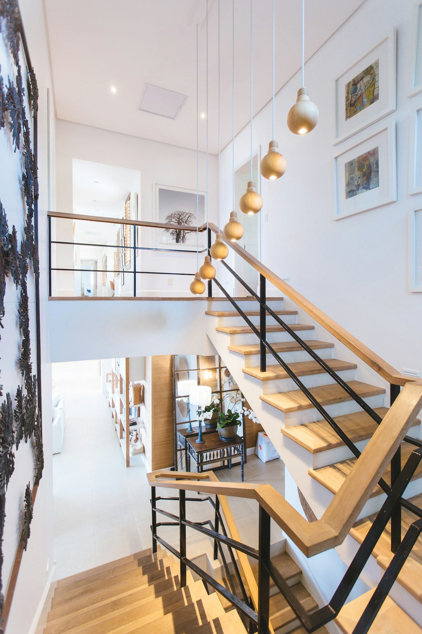 Timber and steel stair rising through a double-height hall